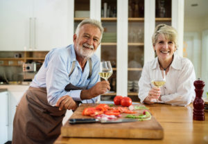 Older couple drinking wine in kitchen